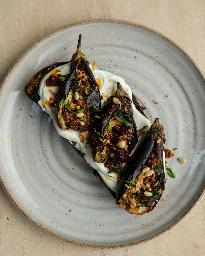 Baby aubergines on toast with Labneh and cumin chilli oil.